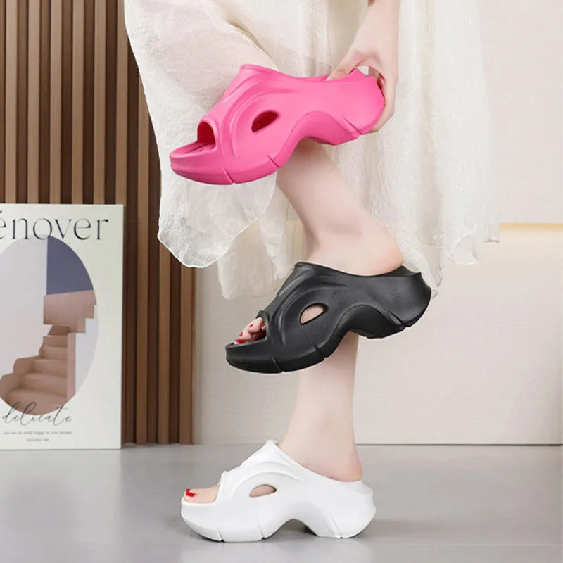 Women's thick-soled EVA slippers in rose red, shown on a beach background.