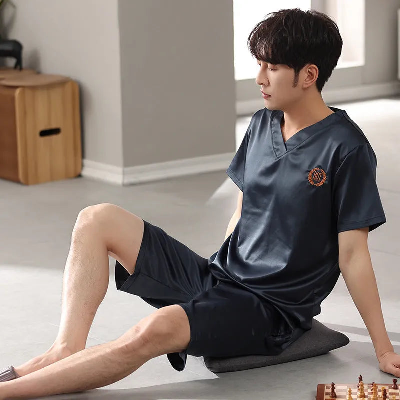 Man wearing a loose grey ice silk short-sleeve pajama shirt and matching shorts.