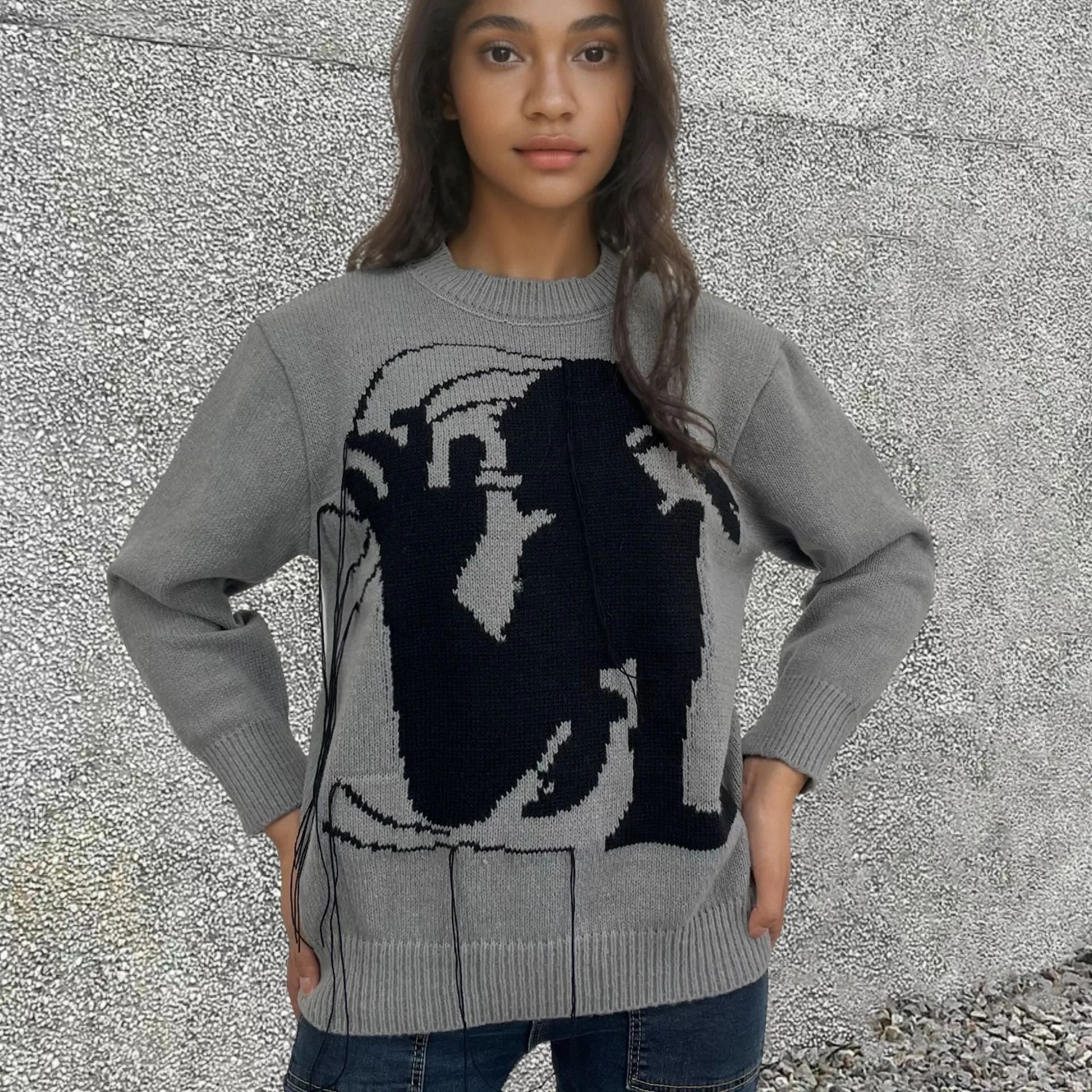 Grey women's alpaca wool pullover sweater with abstract pattern and tassel detailing on a hanger.