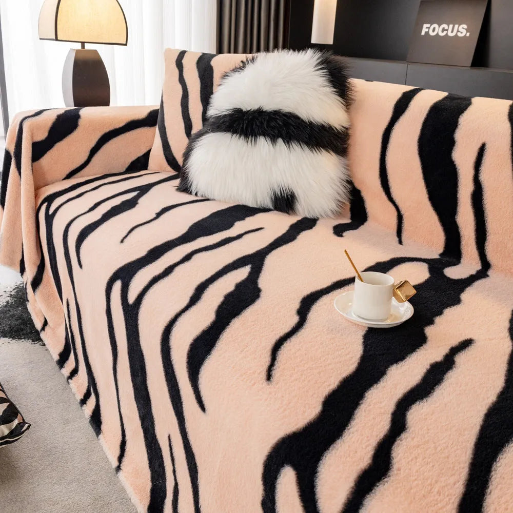 Thickened flannel zebra pattern sofa cover in caramel or black draping over a sofa with non-slip texture visible