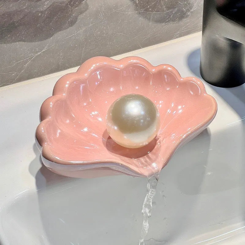 White or pink shell-shaped plastic soap dish for bathroom countertop.