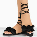 Women's plus size suede flower flat sandals with ankle strap in black, side view