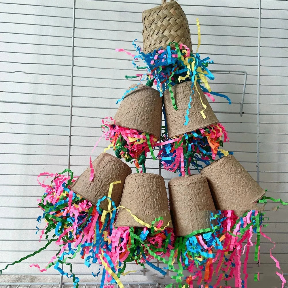 Parrot chew toy with woven palm fibres and a paper cup, hanging 38 cm long in a natural wood colour.