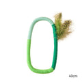 Green circular cotton rope cat toy with feathers and catnip for chewing and kicking play