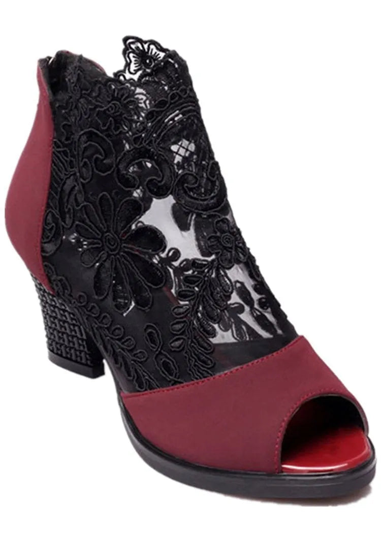 Black lace gladiator sandals with a square high heel and peep toe on a woman's foot