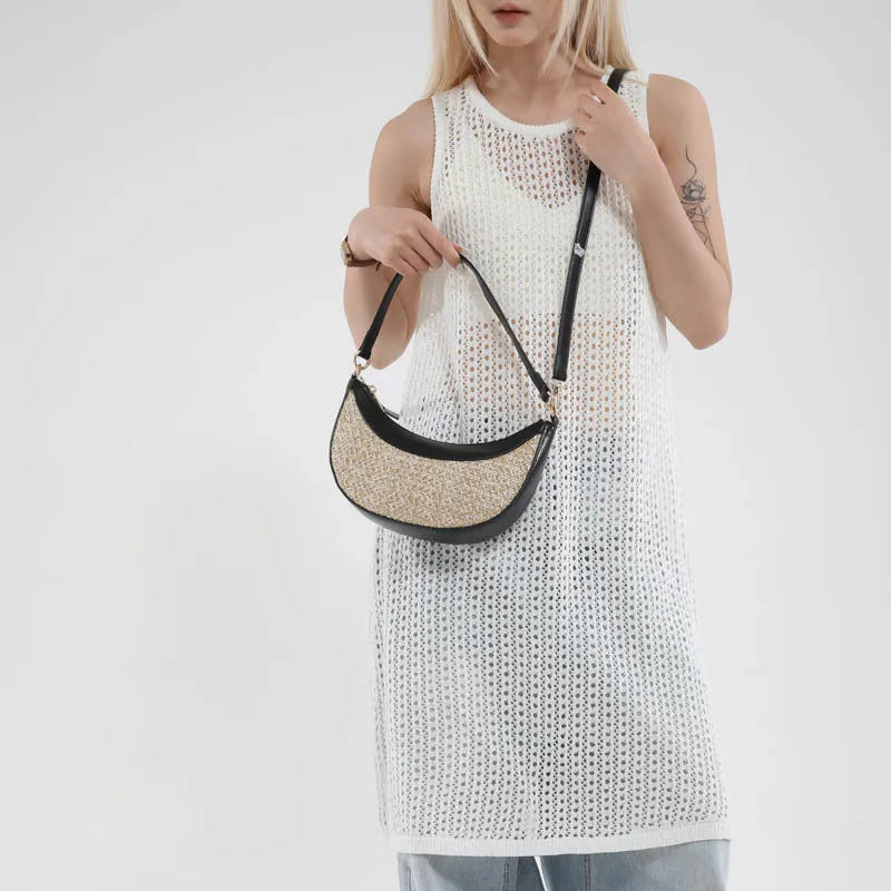Hard woven straw dumpling-shaped crossbody bag in green with contrast stitching and a single shoulder strap.