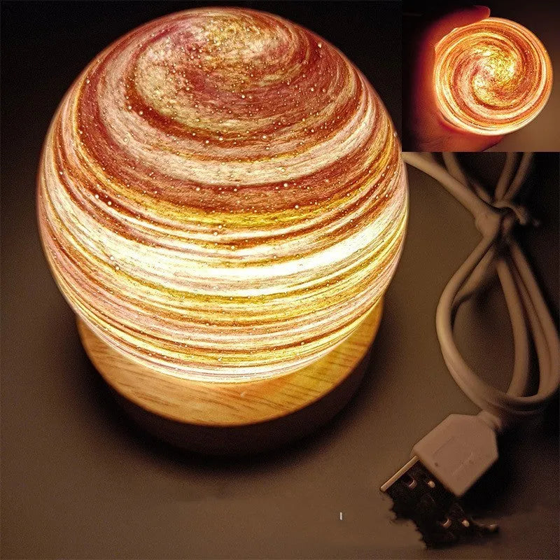 Planets themed USB night light with modern design and three-colour dimming on bedside table.