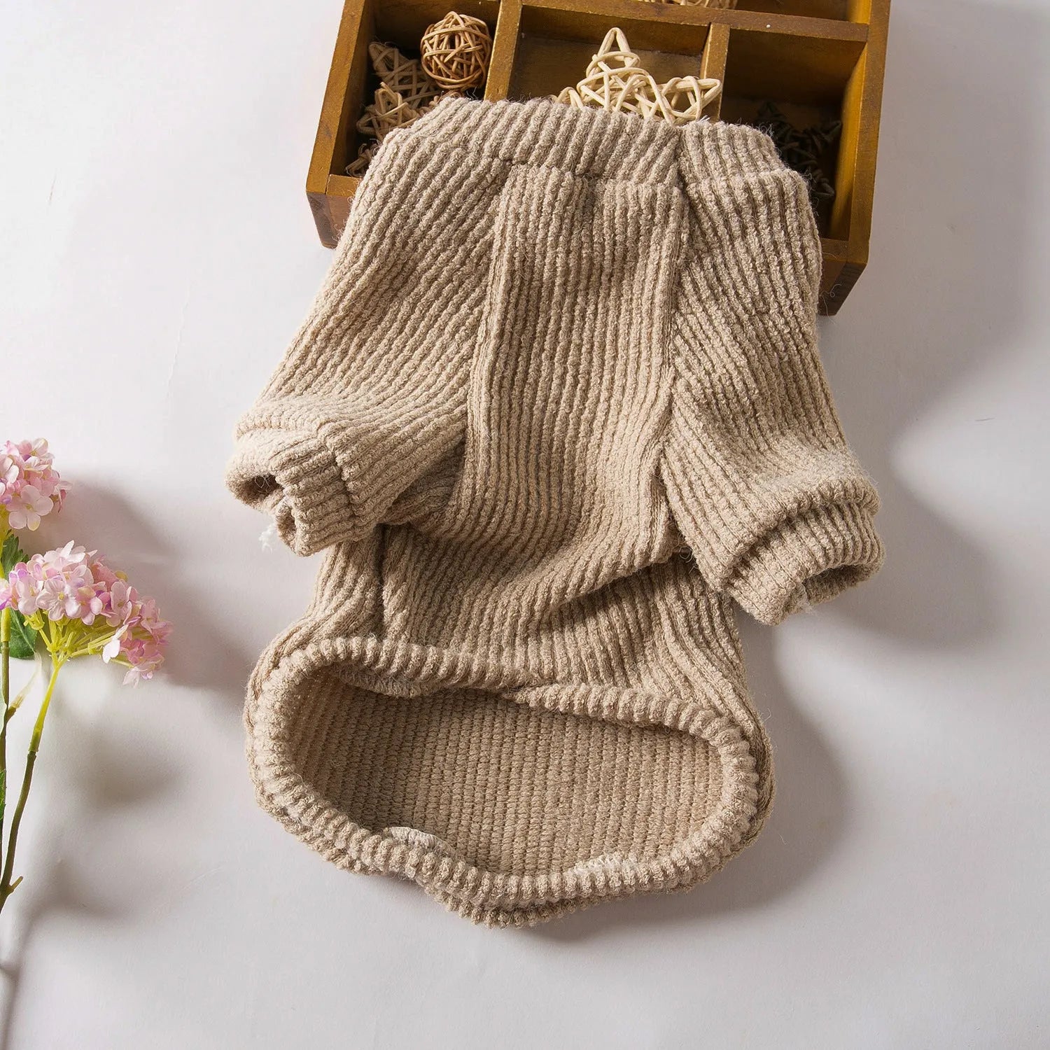 Brown cloth pullover dog sweater on a small breed dog.