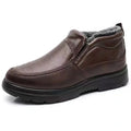 Men's black and brown fleece-lined winter slip-on shoes with rubber soles on a wooden floor.