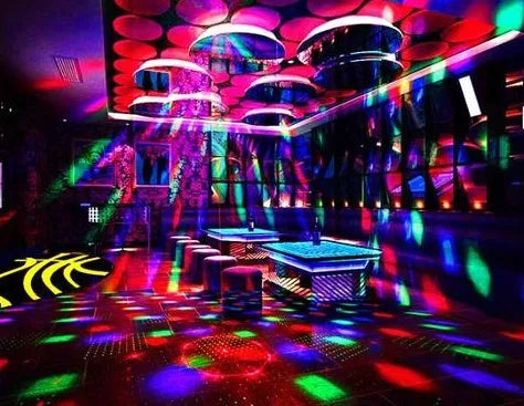 Black and white LED laser magic fan stage light with remote control on a dark background.