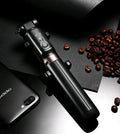 Aluminium Bluetooth selfie stick with tripod base and remote control next to a mobile phone.
