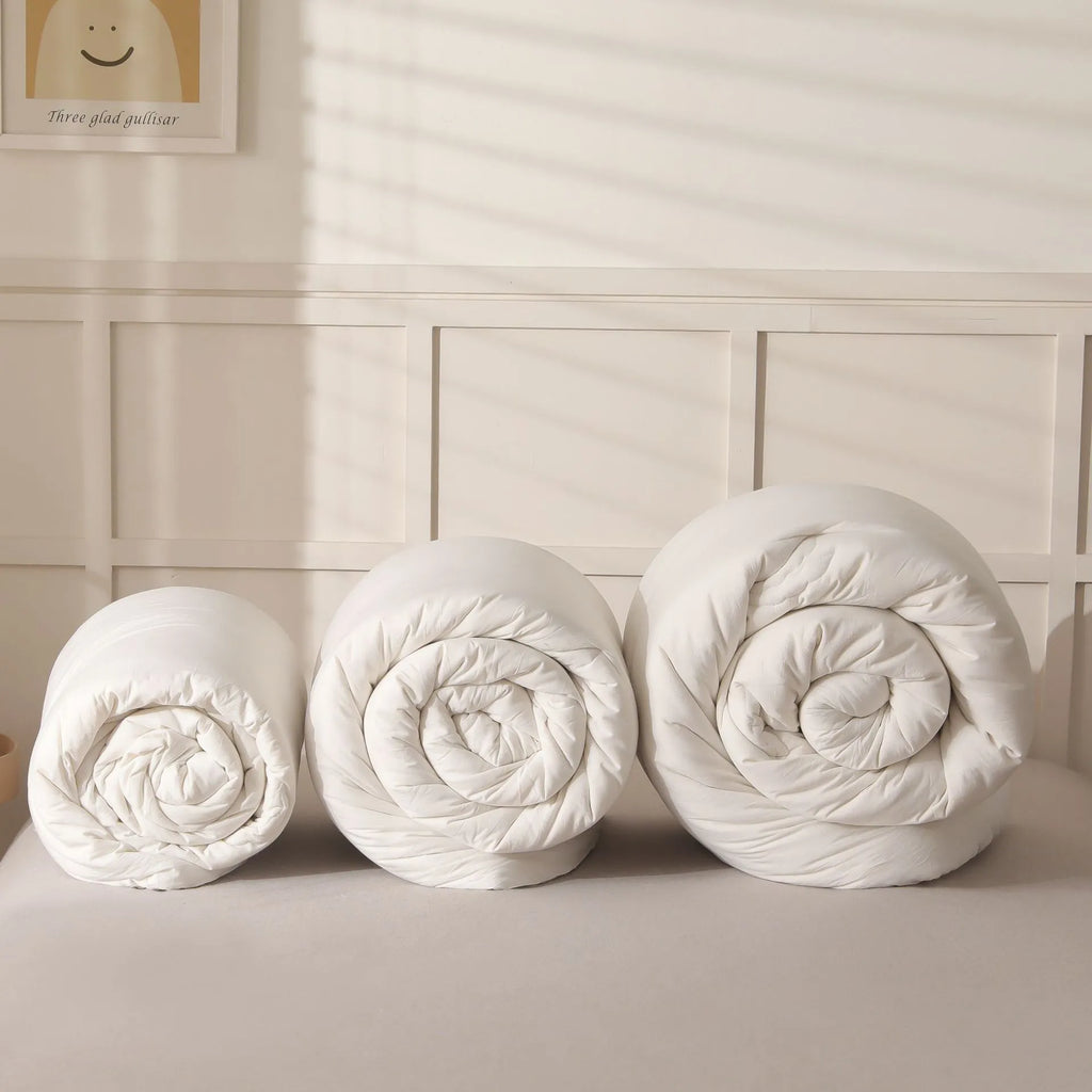 A pure cotton soybean fibre airable quilt in grey, shown with a zipper detail, on a bed.