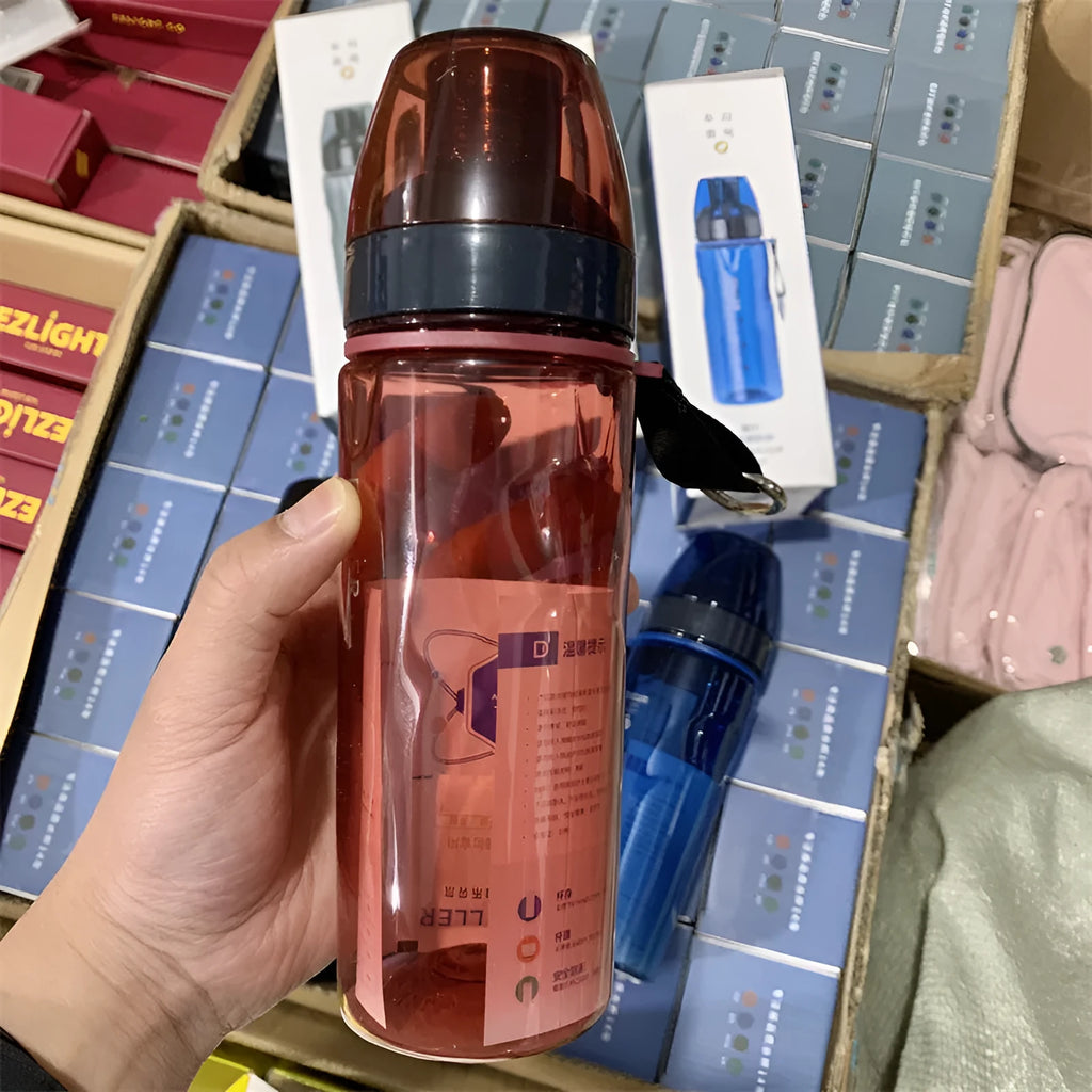 Blue portable sports water cup with a separate compartment for tea leaves on a wooden table.