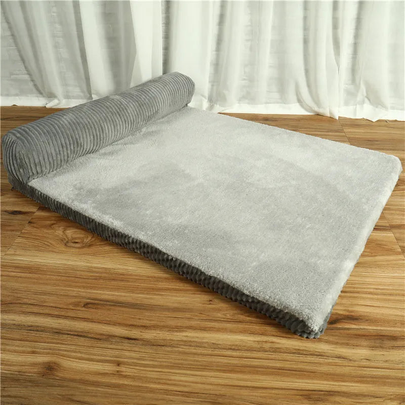 Corduroy dog sofa bed in grey, showing high sides and non-slip base, placed on a wooden floor.