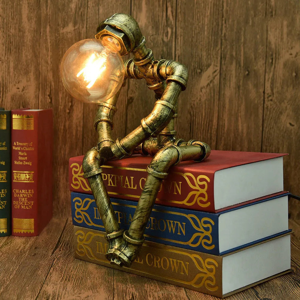 Green bronze vintage robot table lamp with industrial iron pipe design on wooden desk