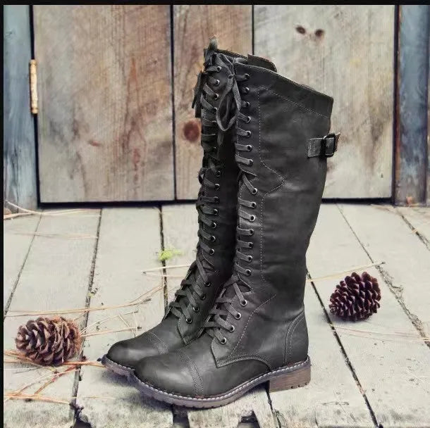 Women's black chunky heel high-leg boots with a round toe and low block heel on a plain background.