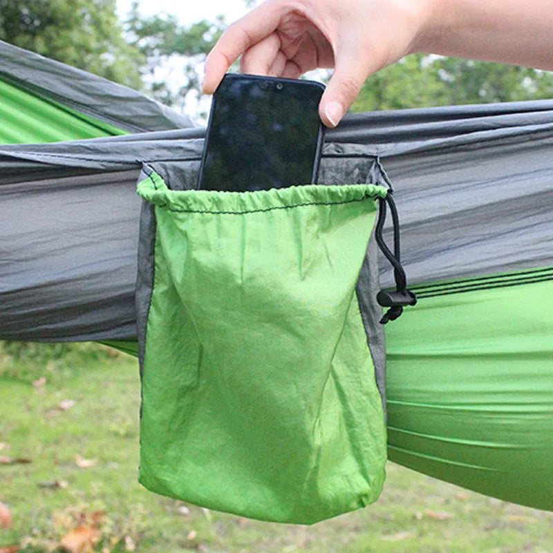 Blue parachute nylon camping hammock hanging between trees with 300kg capacity