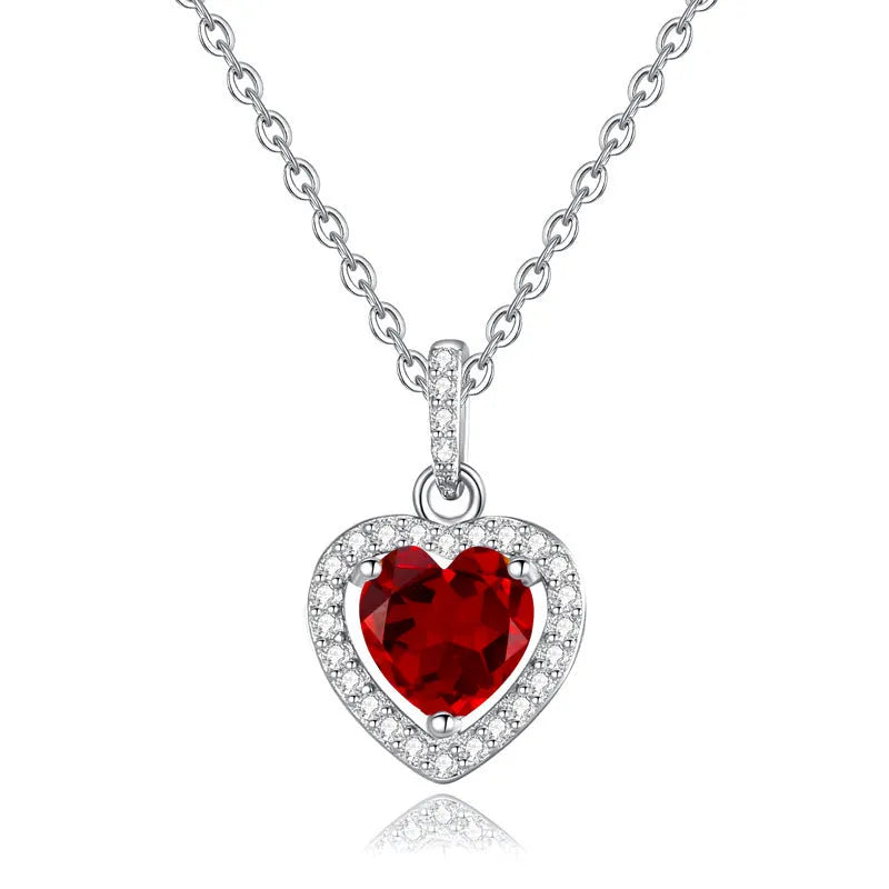 Women's sterling silver necklace with heart-shaped pendant containing natural gemstone on adjustable cross chain