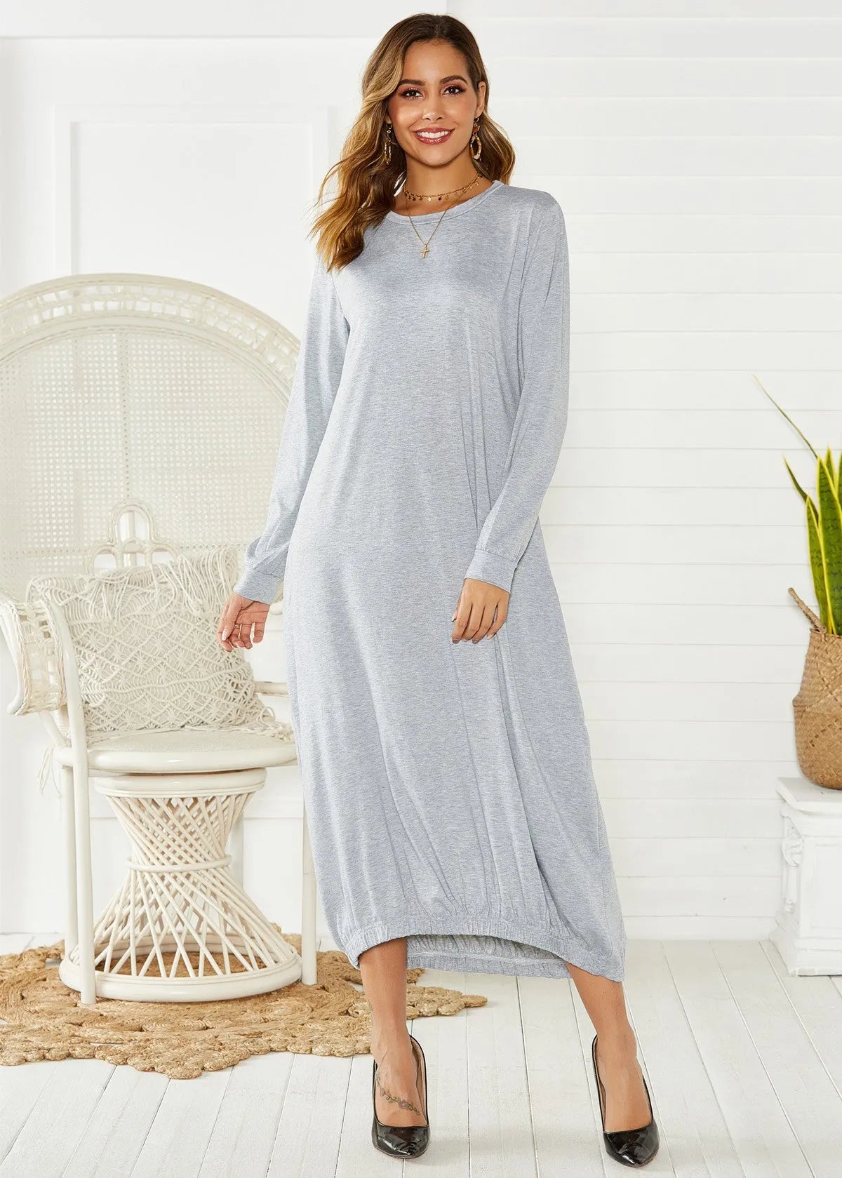 A loose black knitted lantern dress with a lace-up crew neck, showcasing a casual silhouette.