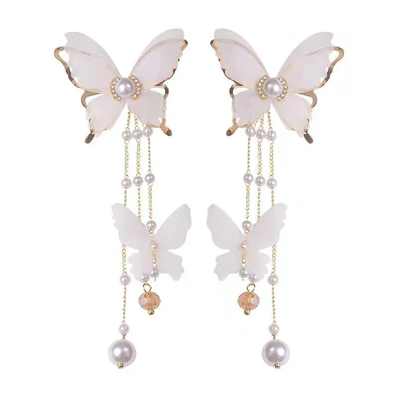 White butterfly-shaped earrings with tassels, pearls, rhinestones, and lace details on electroplated copper alloy