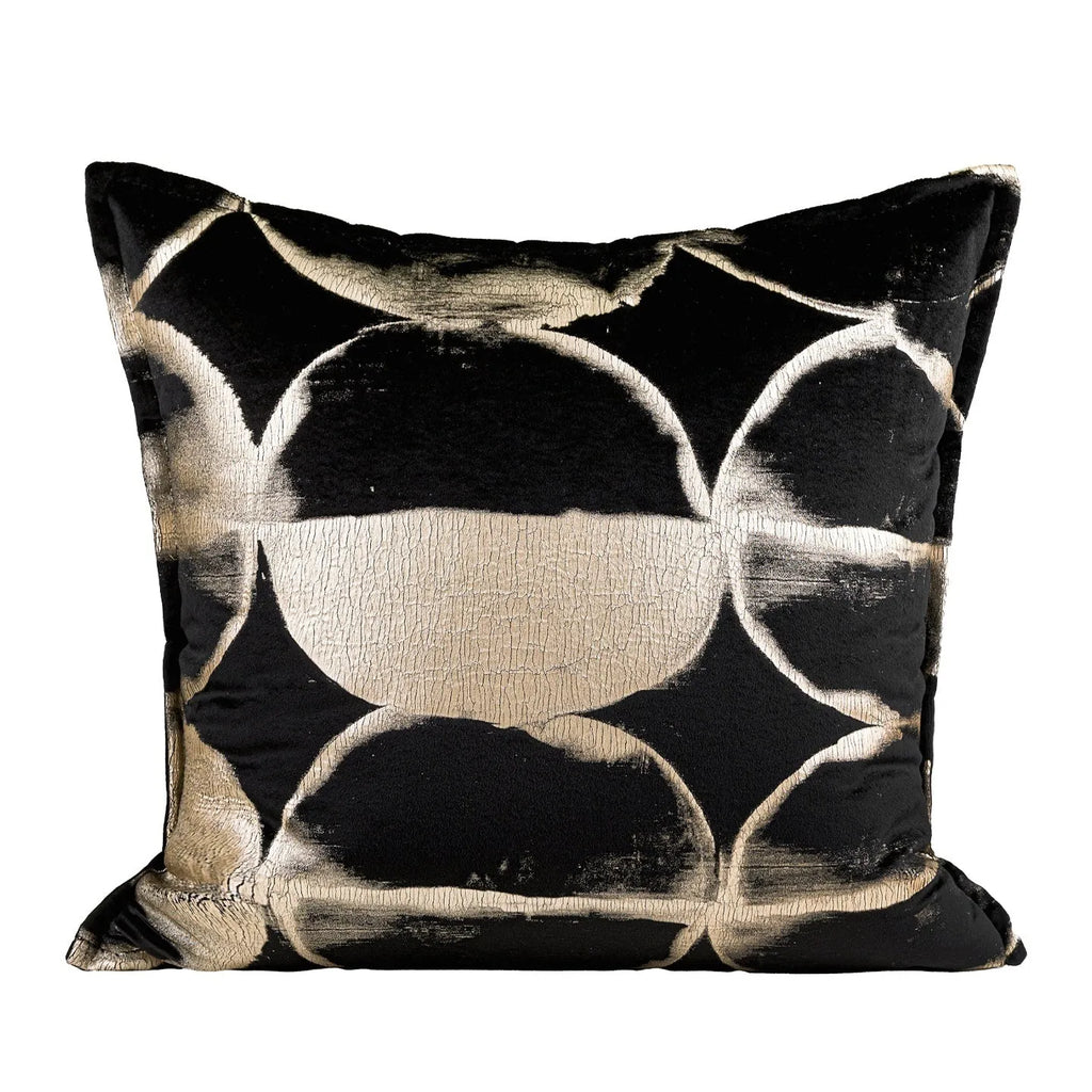 Black and gold abstract patterned flannel cushion in square and bolster sizes on a grey sofa.