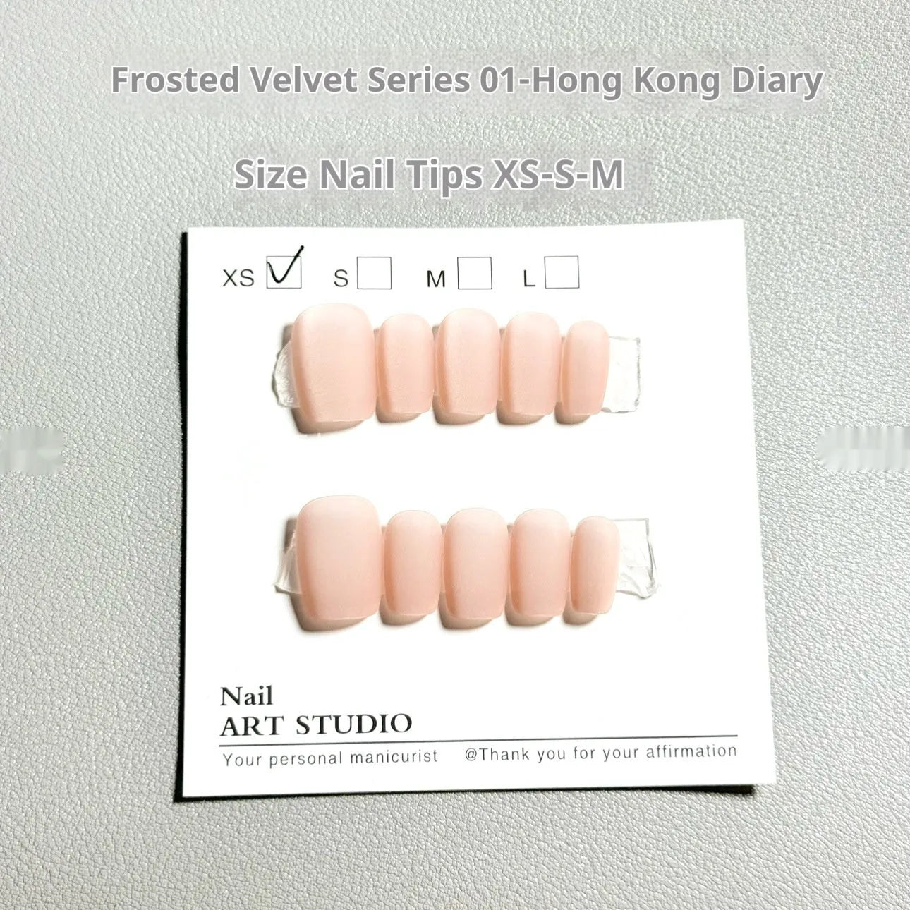 Set of frosted velvet Cat's Eye false nail wraps in short ladder sizes XS, S, and M on a display stand.