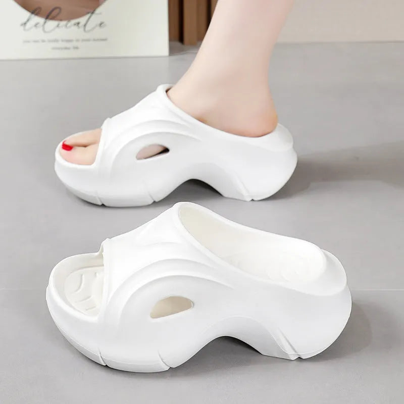 Women's thick-soled EVA slippers in rose red, shown on a beach background.