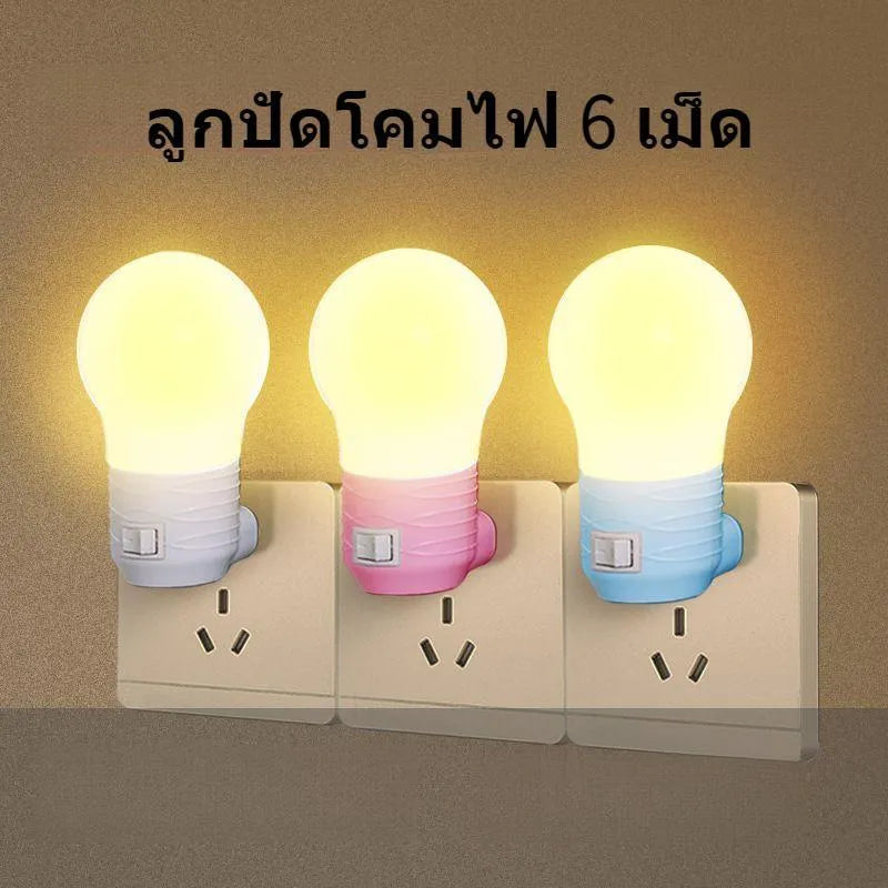 Plug-in bedside baby night light in white, blue, or pink shell with round design on a table