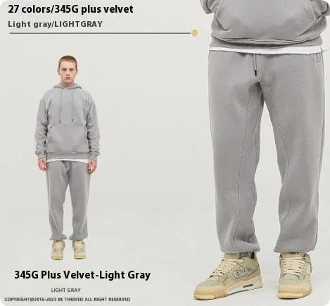 Men's dark brown velvet sweatpants with elastic waistband and banded ankle cuffs on hanger