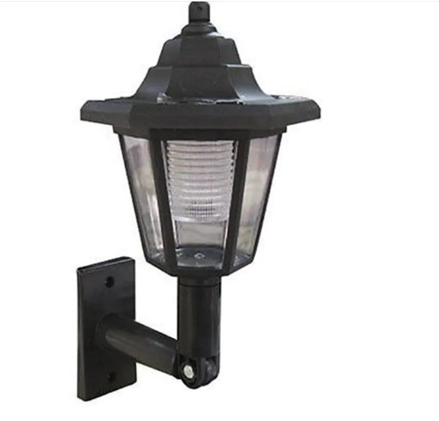 Black hexagonal solar wall lamp with light sensor mounted on an outdoor wall