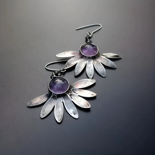 Close-up of purple Bohemian style flower earrings with resin gemstones and Zodiac animal detailing on alloy.