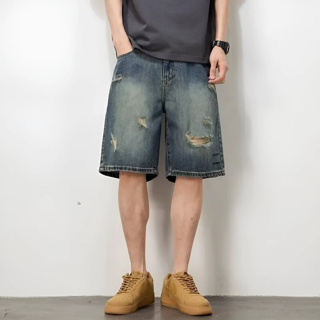 Man wearing blue retro distressed denim shorts with a straight leg cut.