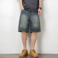 Man wearing blue retro distressed denim shorts with a straight leg cut.