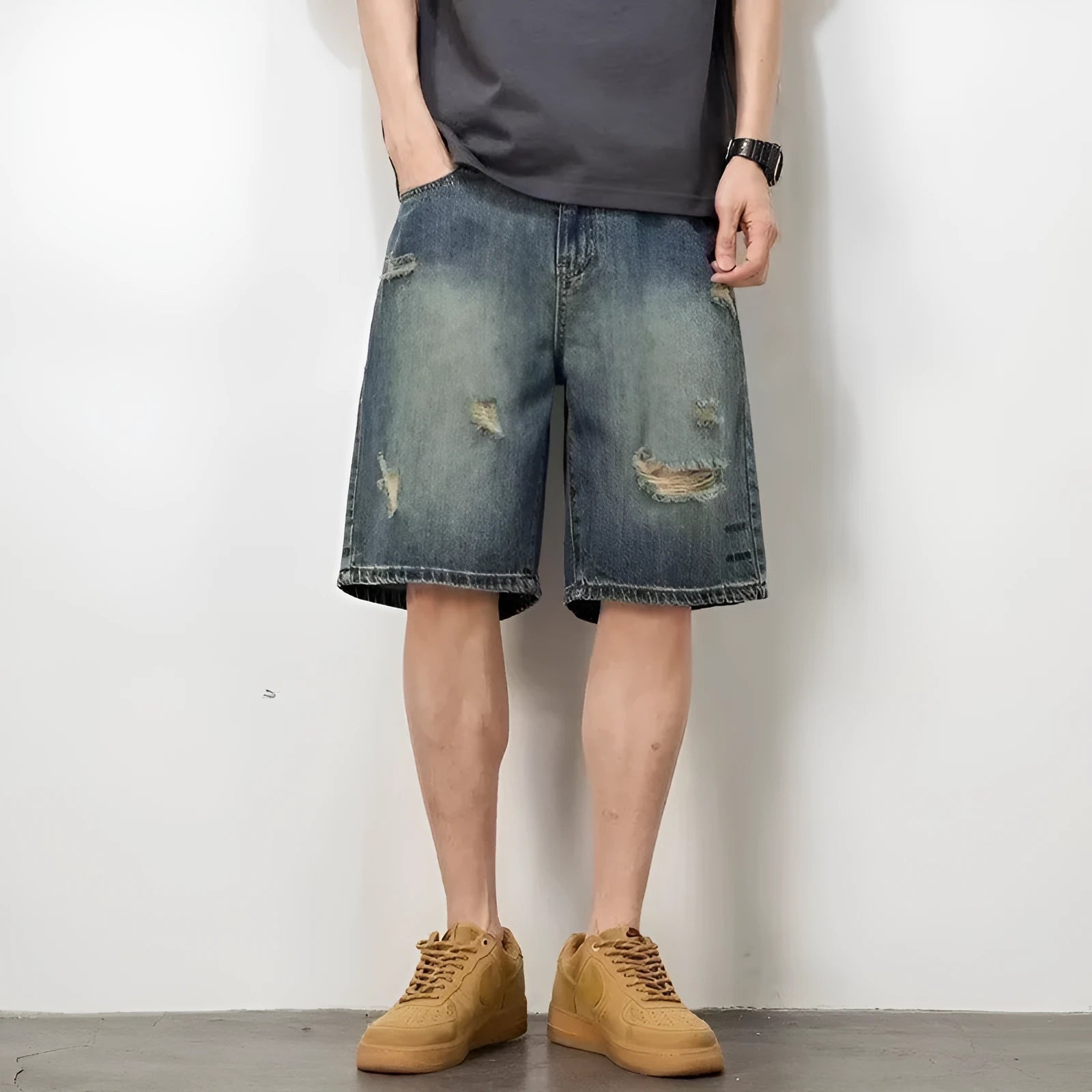 Man wearing blue retro distressed denim shorts with a straight leg cut.