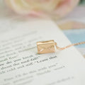 Gold envelope-shaped locket pendant on a stainless steel chain with custom engraving option