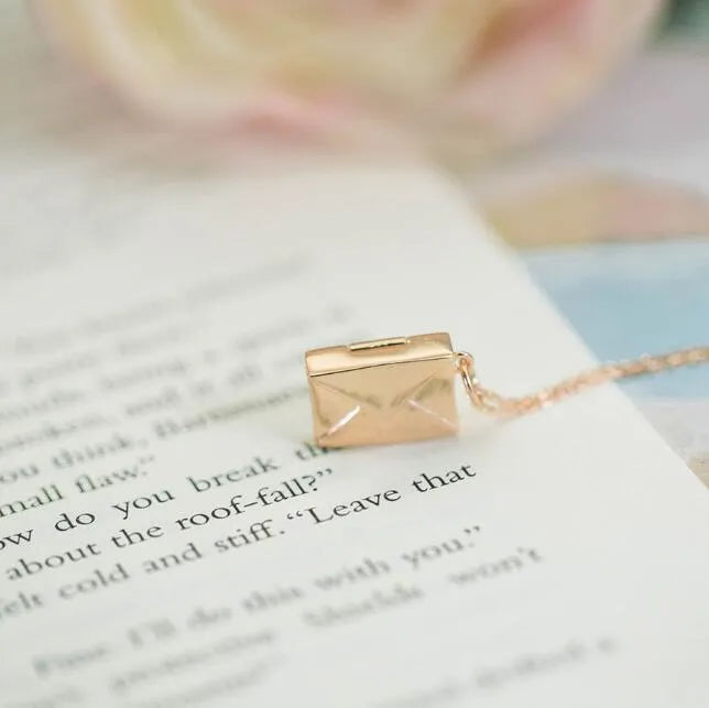 Gold envelope-shaped locket pendant on a stainless steel chain with custom engraving option
