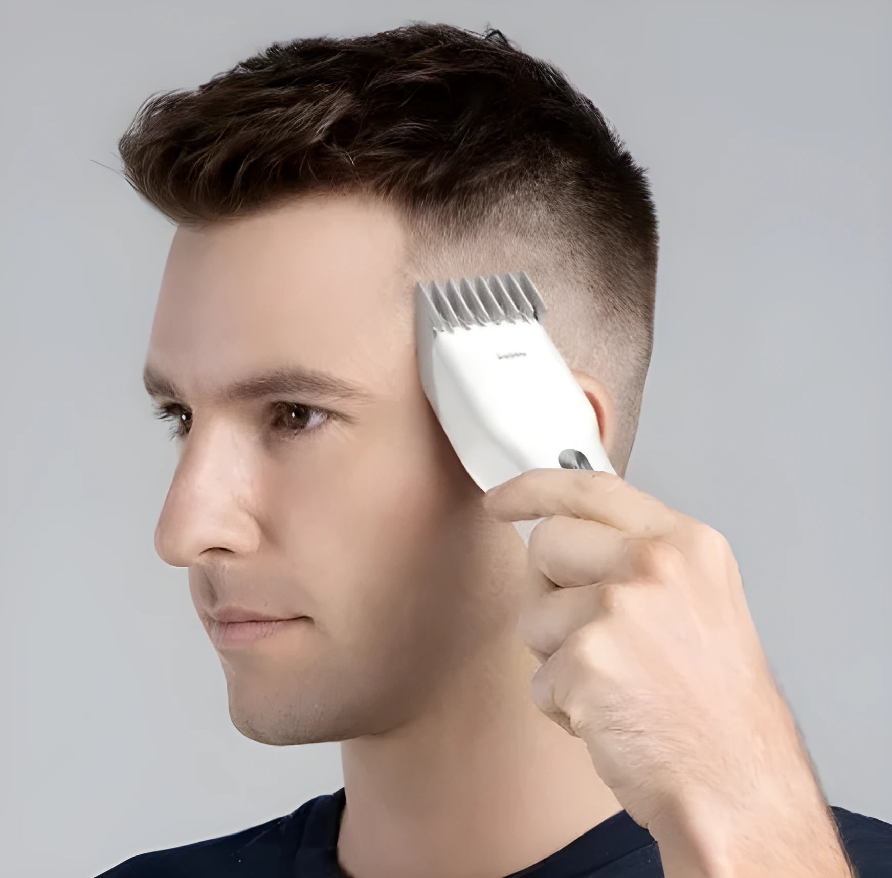 Black cordless electric hair clippers with a ceramic cutter head and a white adjustable length comb attached.