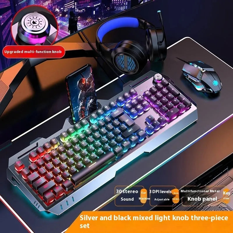 Aluminium gaming keyboard with volume knob, shown in metal grey with RGB lighting alongside optional macro mouse and headset.