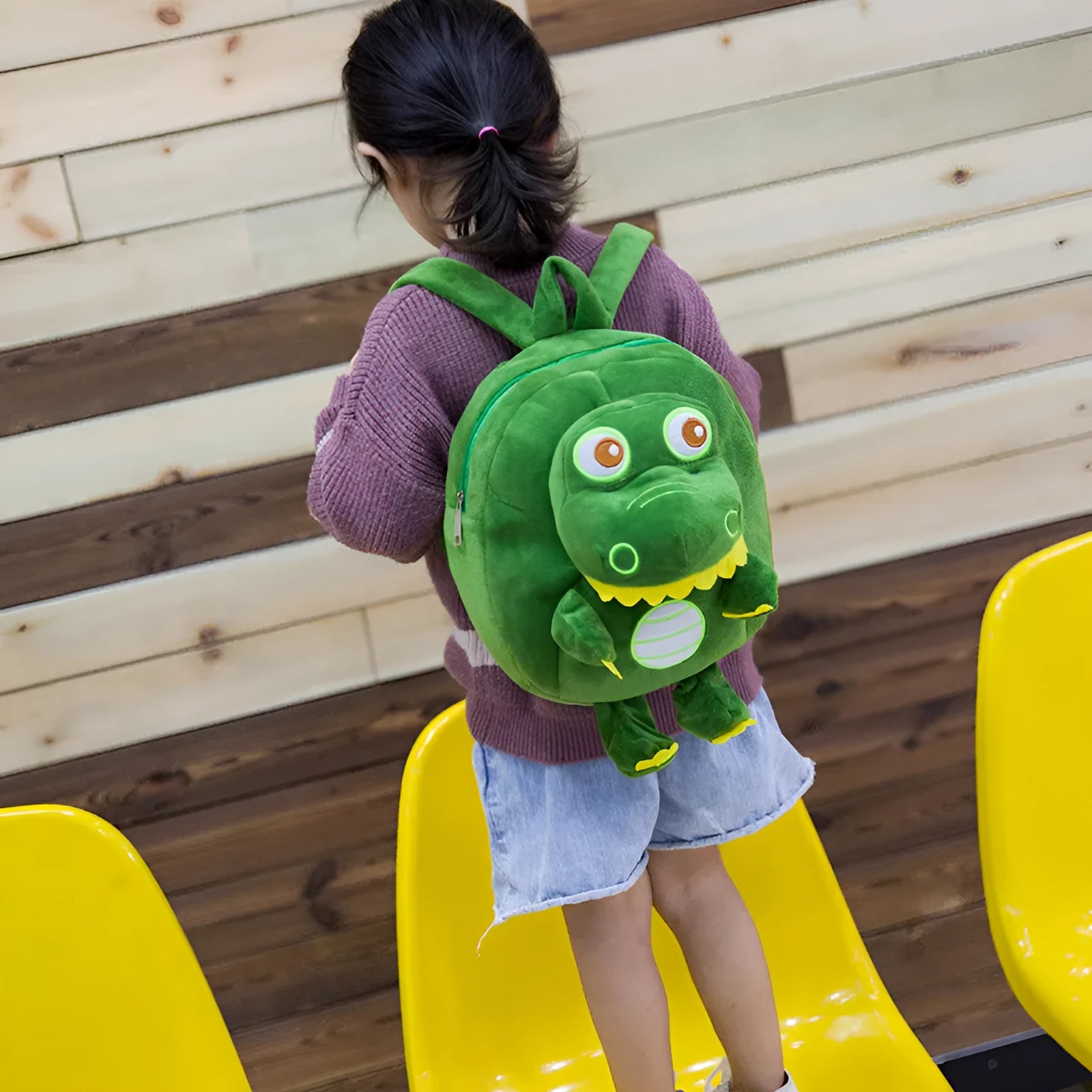Blue soft plush dinosaur backpack for children with embroidered details and a soft carry handle.