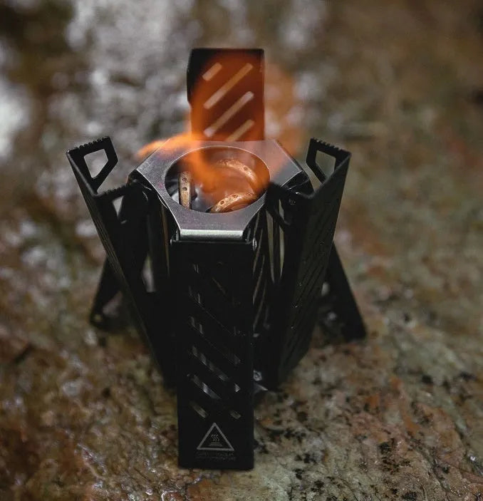 Black hexagon foldable alcohol stove for outdoor camping measuring 9.5x8.5x15cm