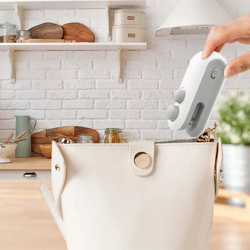 Handheld bag heat sealer in white and blue with USB charging port and cutter blade