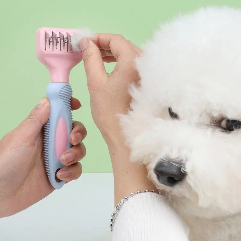 Pink pet grooming comb with stainless steel knot knife, massage brush head, and comb teeth on a white background.