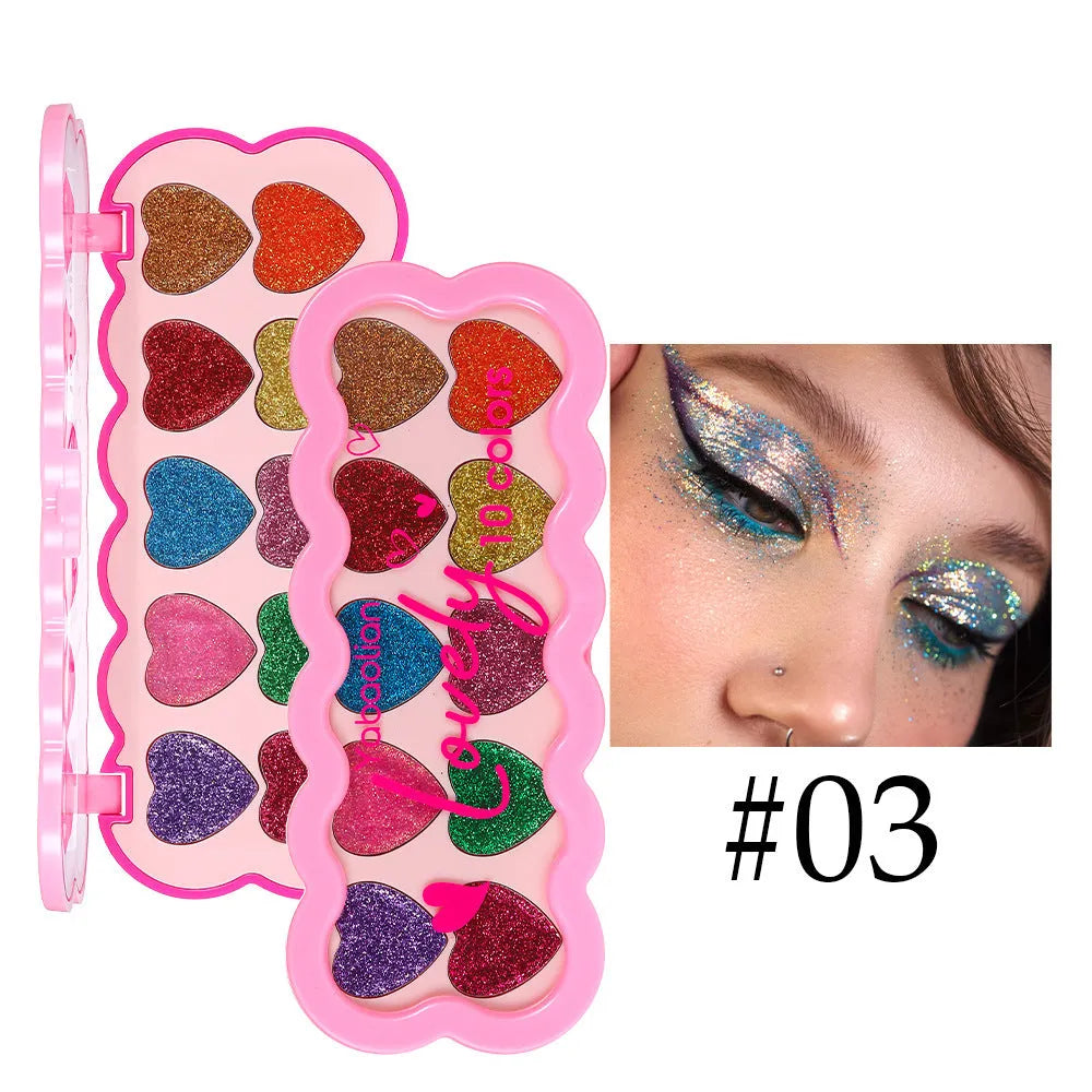 Heart-shaped case open to show ten eyeshadow pans in white, beige, pink, purple, brown, blue, black, royal blue, maroon, and coral.