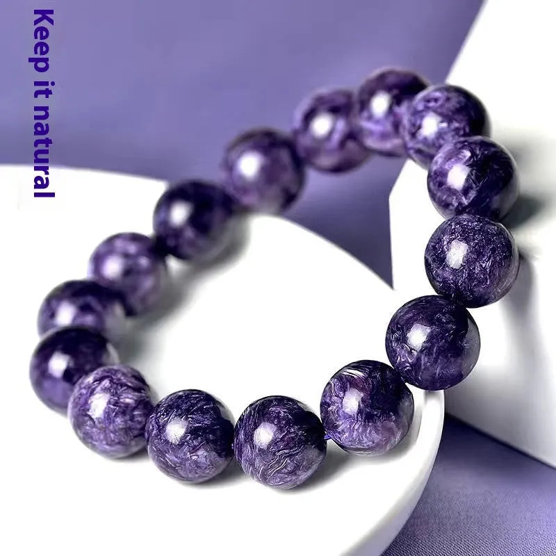 Natural transparent charoite crystal bracelet with platinum settings on wrist.