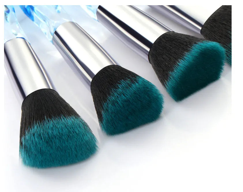Ten crystal-handle foundation makeup brushes with synthetic bristles laid out flat
