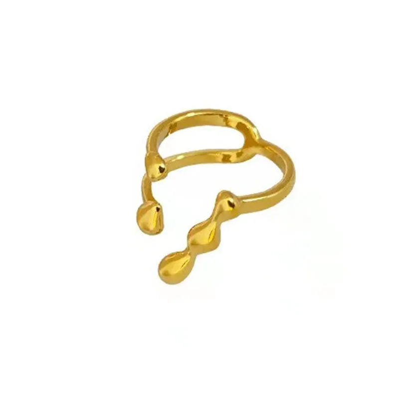 Gold or silver brass opening ring with spherical design elements on a model's finger.