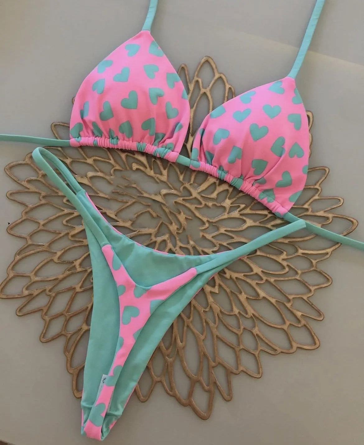 Heart print backless one-piece swimsuit with a split briefs style on a mannequin.
