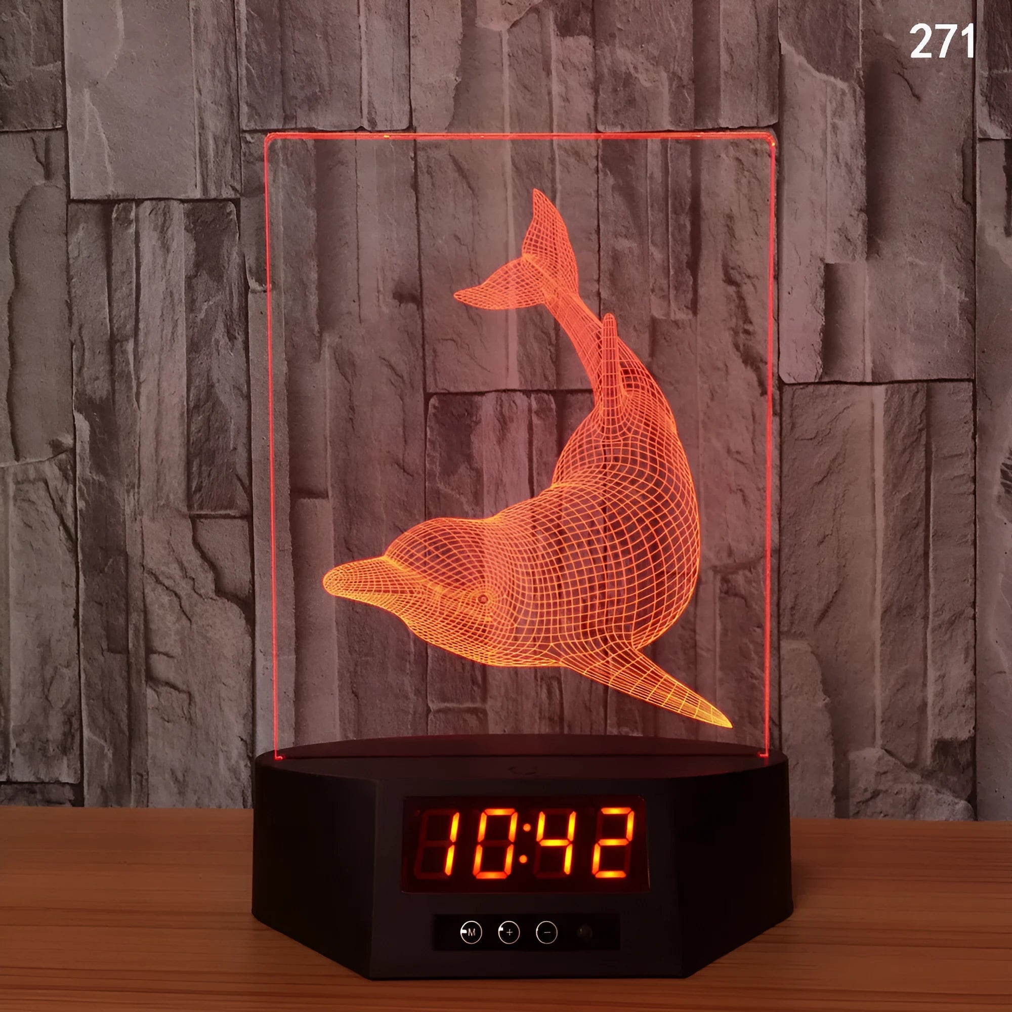3D glowing dolphin shaped LED table lamp with remote control on a bedside table.