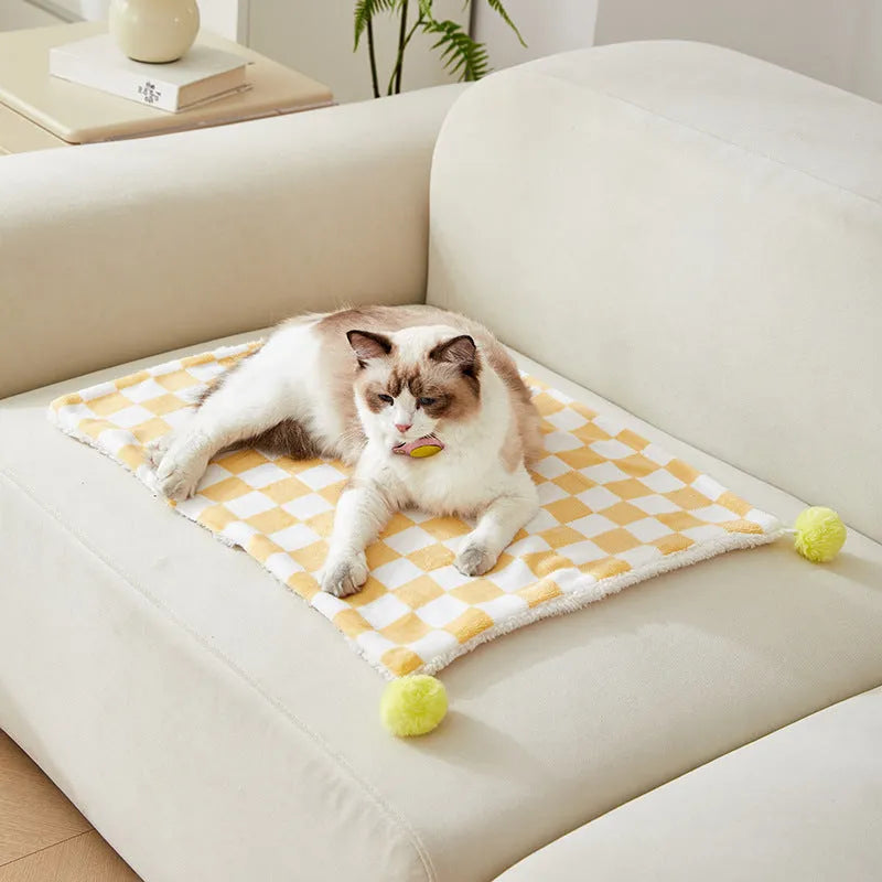 Green plaid plush pet blanket for dogs and cats on a sofa
