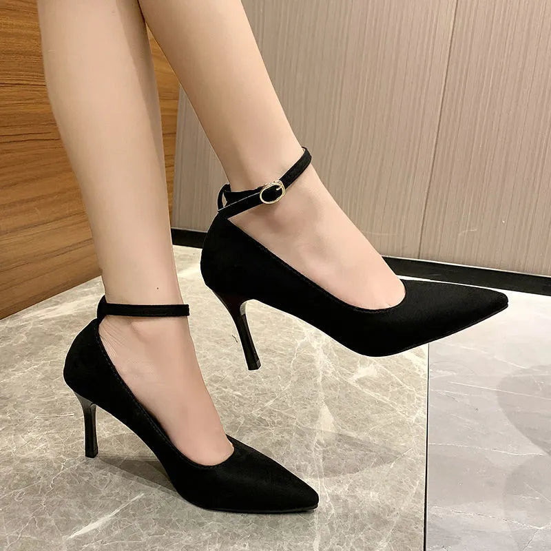 Women's black stiletto heel pump shoe with a silver buckle detail on the front.